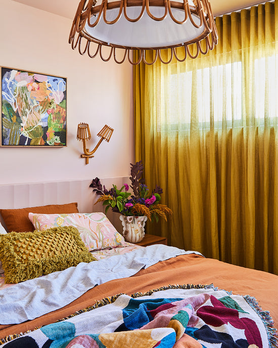Detail of chartreuse curtain by Champion Blinds framing a light-filled bedroom designed by Nikki McGar Interiors.