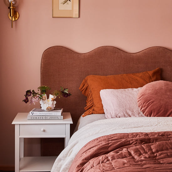 Playful pink wave bedhead in a modern Bright Airbnb bedroom designed by Nikki McGar Interiors.