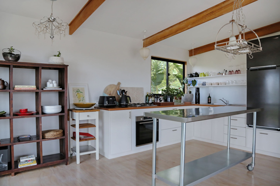 Before: Original Merimbula Airbnb kitchen prior to renovation by Nikki McGar Interiors, with outdated cabinetry and limited natural warmth.