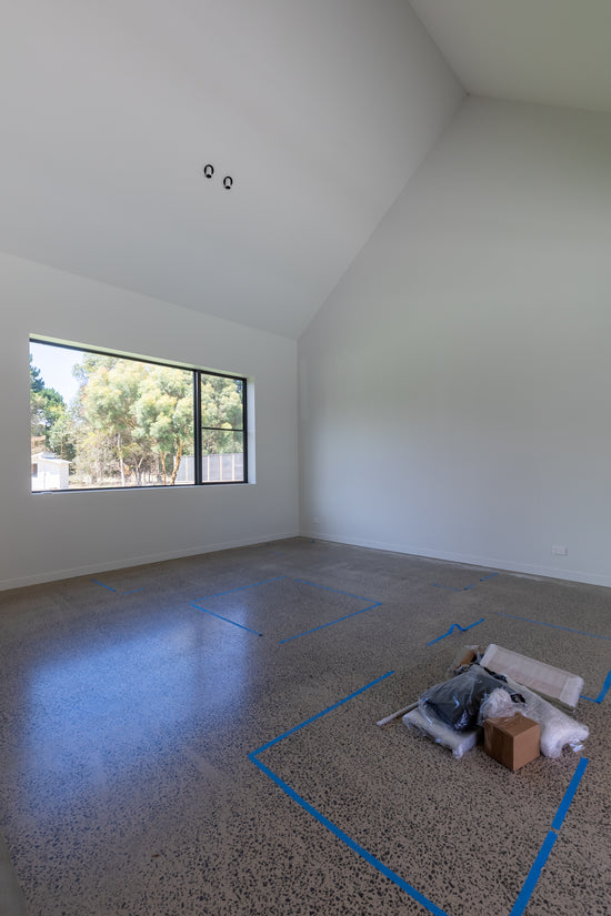 Before: Wallington living room prior to renovation by Nikki McGar Interiors, with minimal colour and  concrete floor and white walls