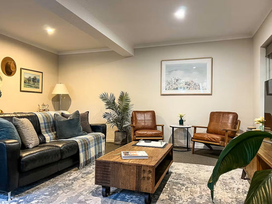 Before: Airbnb living room prior to renovation by Nikki McGar Interiors, with minimal colour and simple furnishings.