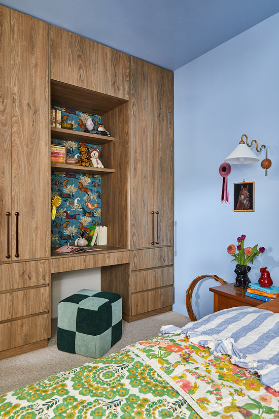 Kid’s custom-designed wardrobe and desk space with Laminex cabinetry, bronze handles, and a built-in pinboard by Nikki McGar Interiors.