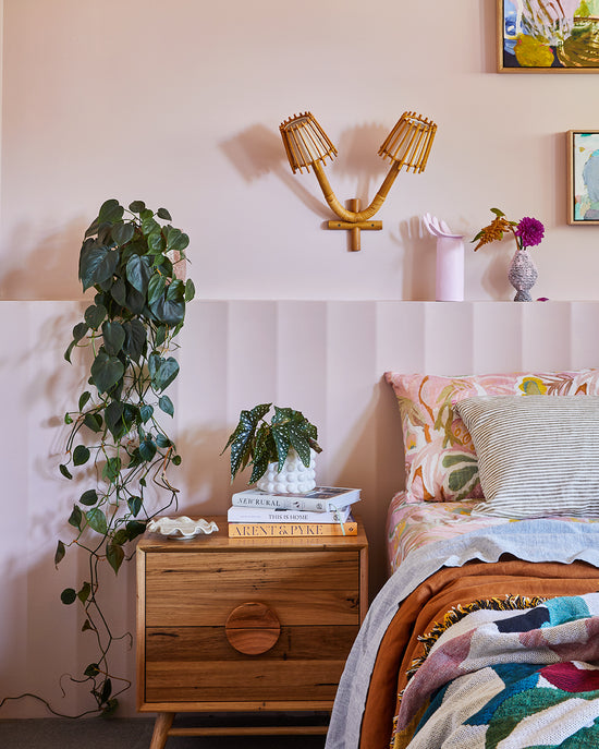 Bedroom renovation by Nikki McGar Interiors featuring a built-in bedhead and rattan wall light for a natural, coastal-inspired look.